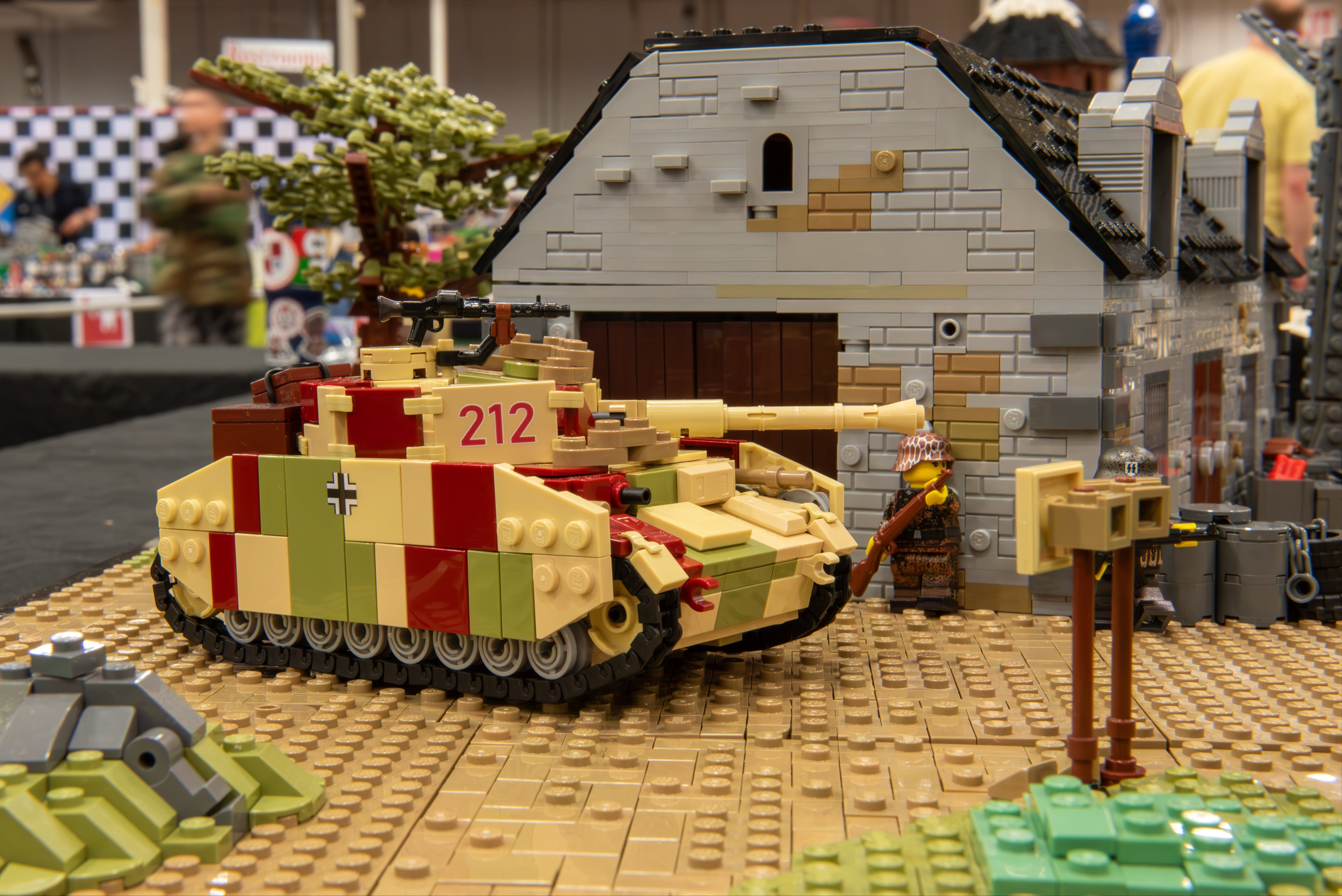 LEGO tank and building set on a table with a checkered background