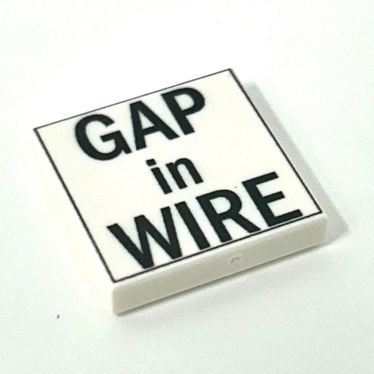 Square tile with 'Gap in Wire' text on a white background
